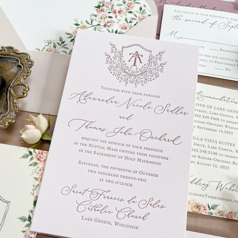 Classic wedding invitation with a crest in letterpress with watercolor floral designs