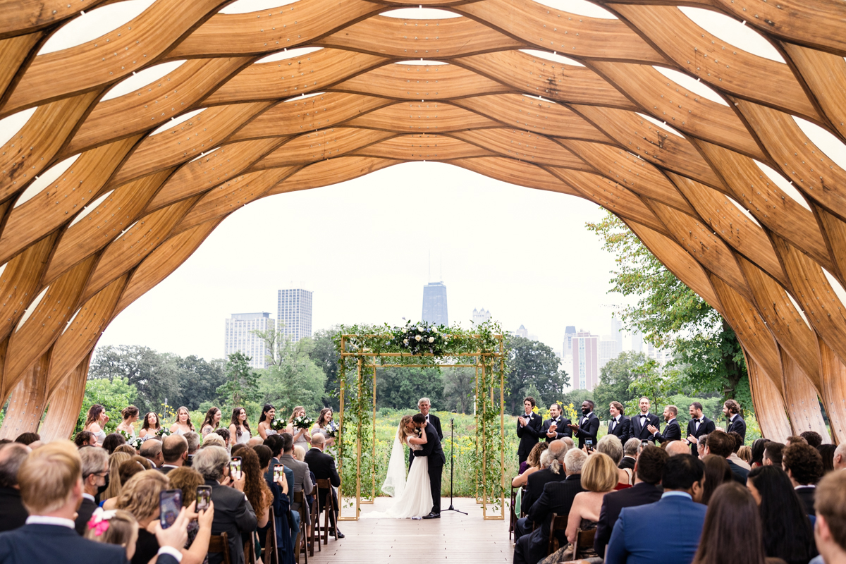 Just married bride and groom kiss underneath Honeycomb in Lincoln Park