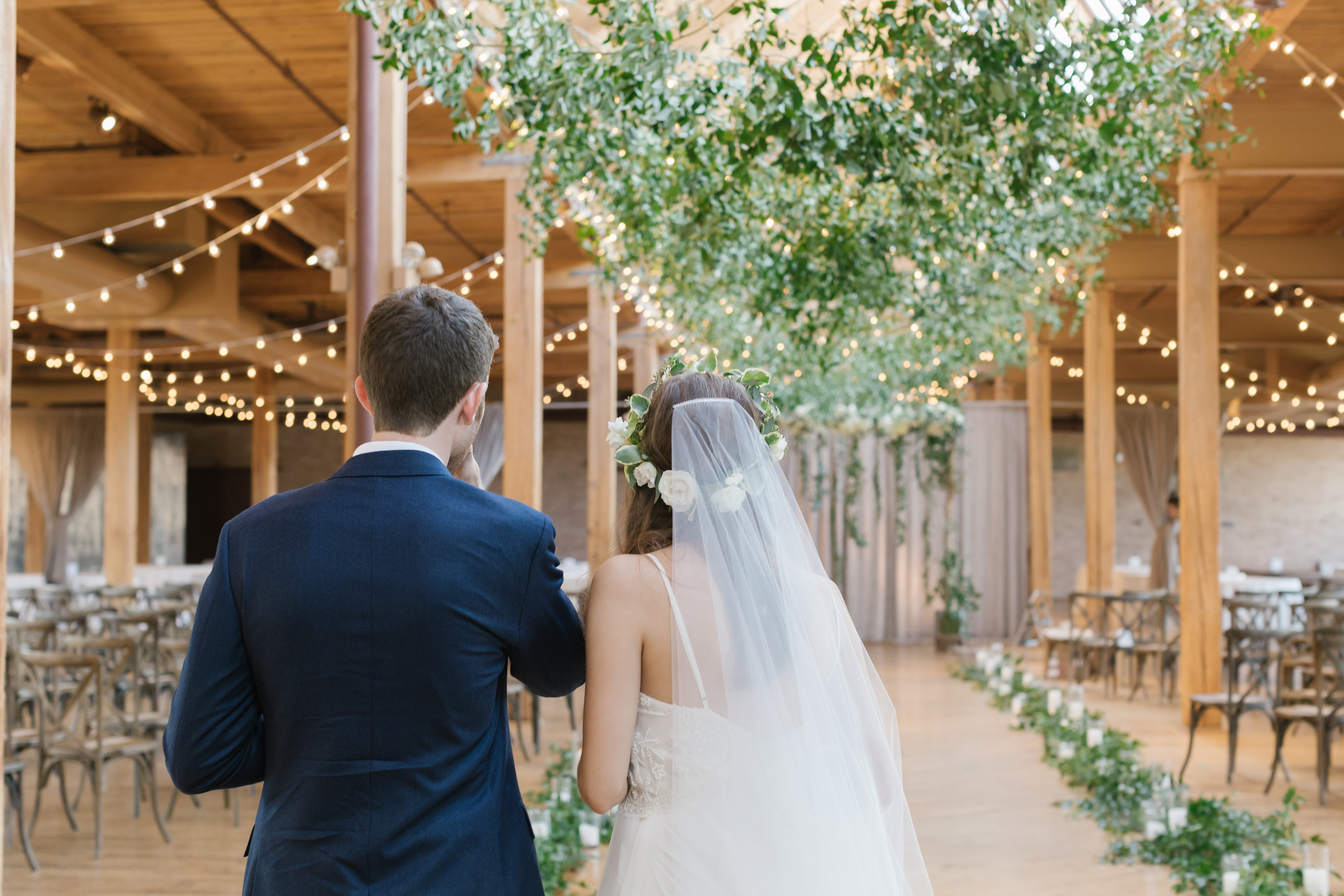 Greenery & Cafe Glove Lights down center aisle + N & South sides with Greenery Arch