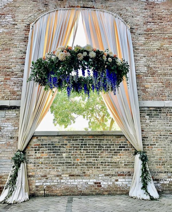 close up of larger arch draped + hanging greenery halo