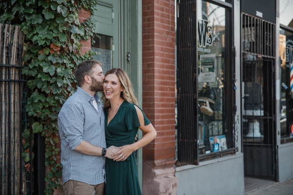 Couple laughing together in front of ivy