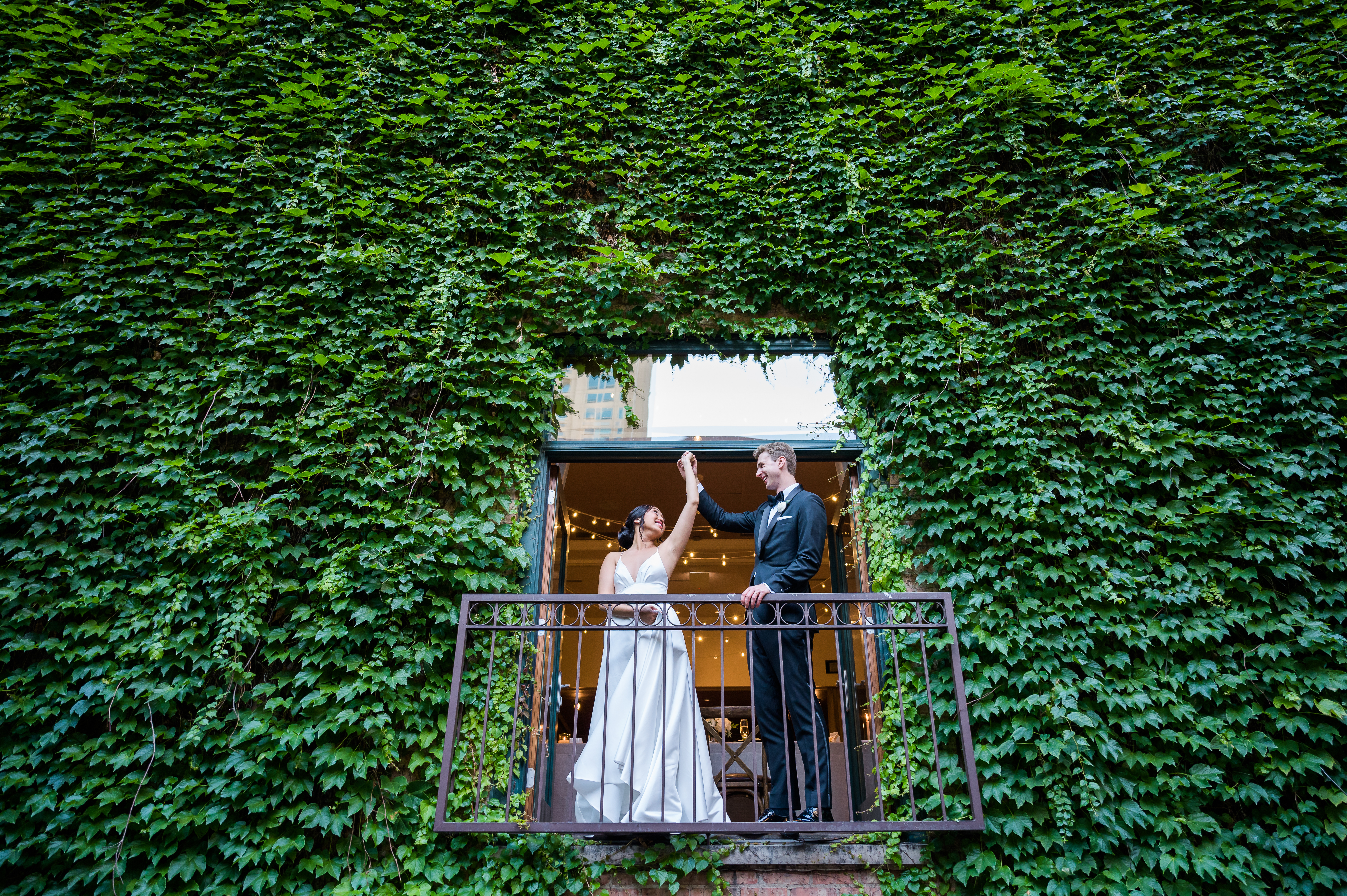 Bride and groom standing on a balcony twirling at The Ivy Room in Chicago