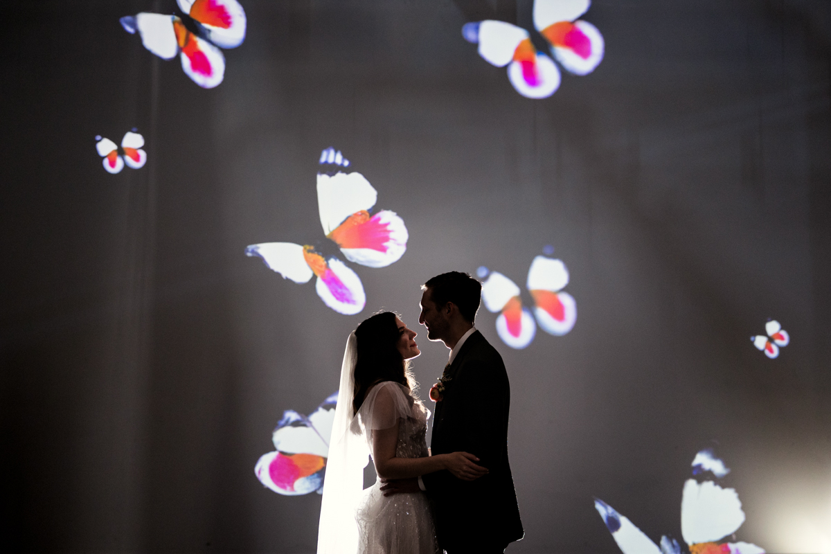 Romantic silhouette photo of bride and groom with butterflies projected image at Wildman BT wedding venue